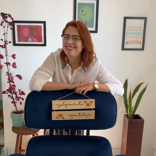 Natália Araújo no consultório, com a placa 'menos julgamento, mais gentileza'